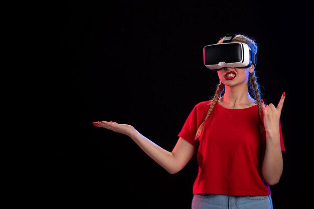 Vooraanzicht van jonge vrouw die vr op donkere muur speelt