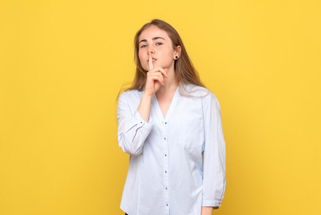 Vooraanzicht van jonge vrouw die vraagt om stil te zijn