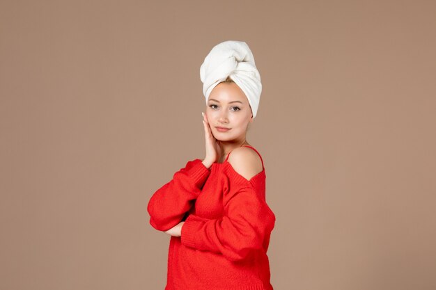 vooraanzicht van jonge vrouw in rood shirt met handdoek op haar hoofd bruine muur