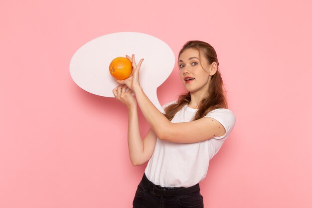 Vooraanzicht van jonge vrouw in wit t-shirt met grapefruit en wit bord