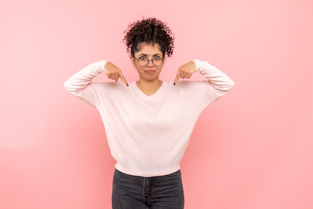 Vooraanzicht van jonge vrouw ontevreden op roze muur