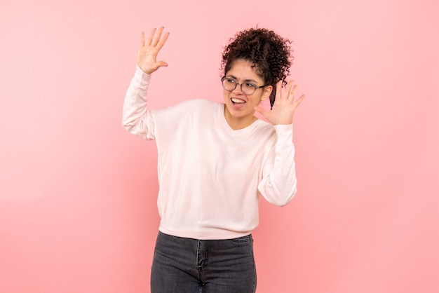 Vooraanzicht van jonge vrouw op de roze muur