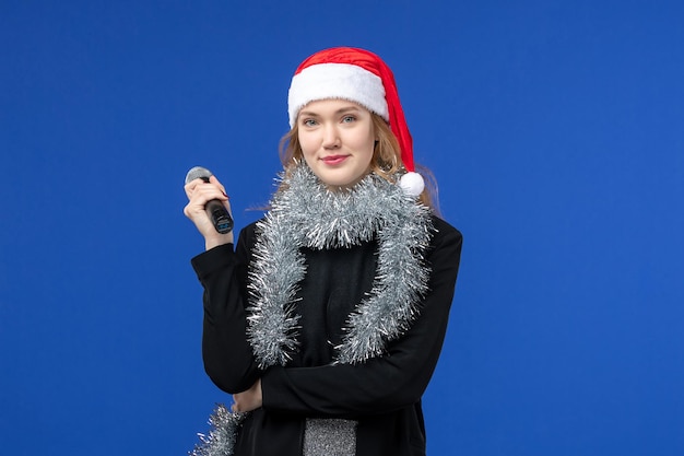 Gratis foto vooraanzicht van jonge vrouw op nieuwjaarskaraokefeest op de blauwe muur