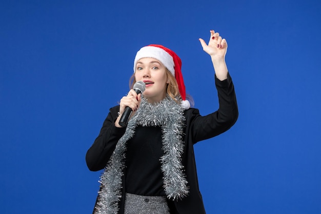 Gratis foto vooraanzicht van jonge vrouw op nieuwjaarskaraokefeest op de blauwe muur