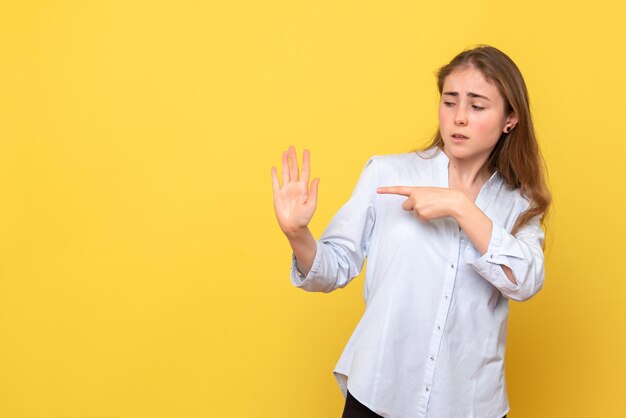 Vooraanzicht van jonge vrouw wijzend op haar handpalm