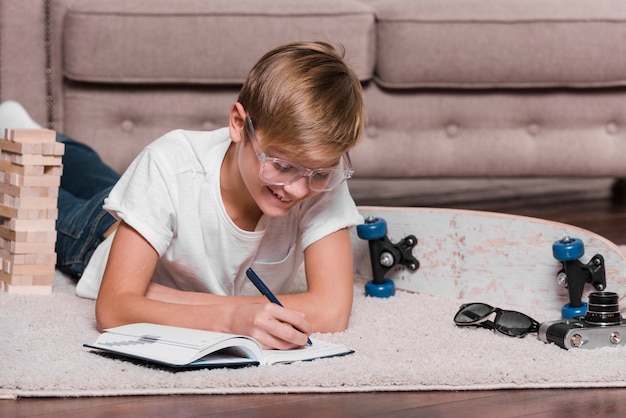 Vooraanzicht van jongen die in een agenda schrijft