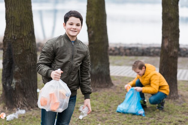 Vooraanzicht van jongens die de grond schoonmaken