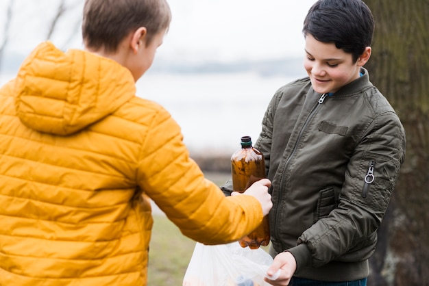 Vooraanzicht van jongens met plastic zak