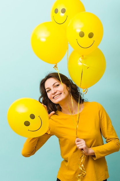 Vooraanzicht van lachende vrouw met ballonnen