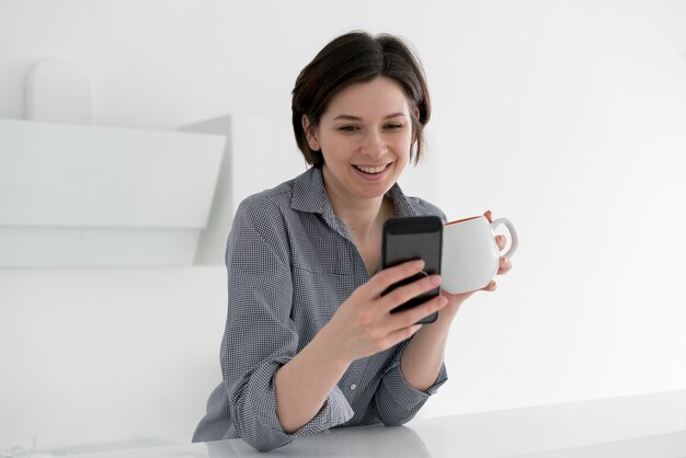 Vooraanzicht van lachende vrouw met koffie