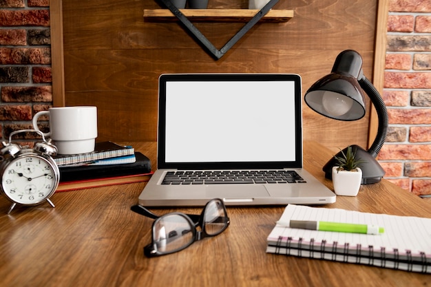Vooraanzicht van laptop en lamp op houten bureauwerkruimte