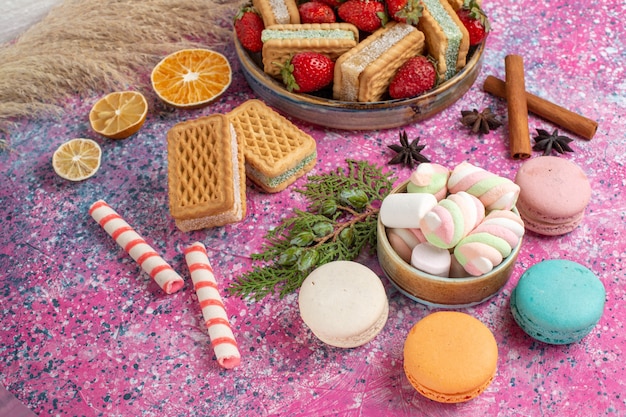 Vooraanzicht van lekkere wafelkoekjes met verse rode aardbeien op de roze muur