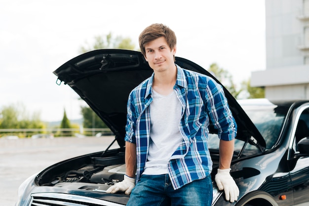 Vooraanzicht van man zittend op auto