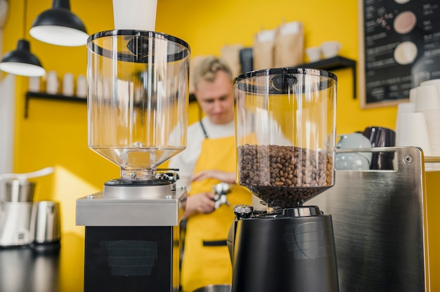 Gratis foto vooraanzicht van mannelijke barista met schort in winkel