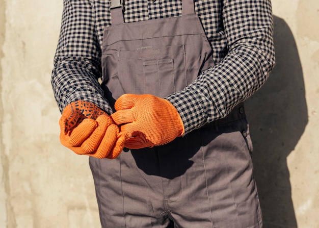 Vooraanzicht van mannelijke werknemer in uniform met beschermende handschoenen