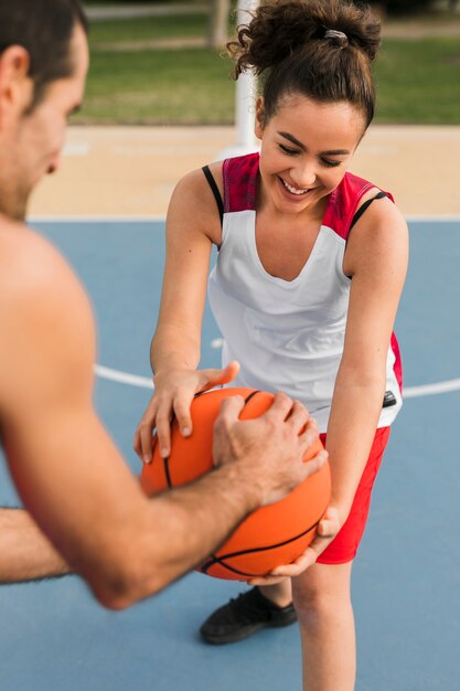 Vooraanzicht van meisje en jongen spelen basketbal