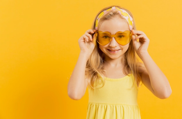 Gratis foto vooraanzicht van meisje het stellen met zonnebril