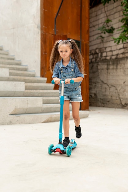 Vooraanzicht van meisje op blauwe scooter