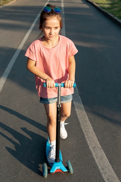 Gratis foto vooraanzicht van meisje op blauwe scooter