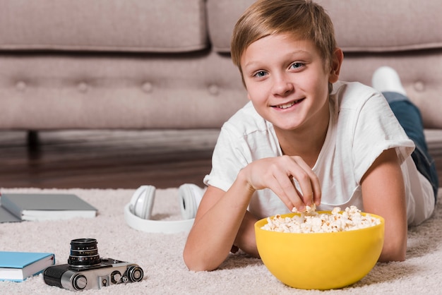 Vooraanzicht van moderne jongen die popcorn eet