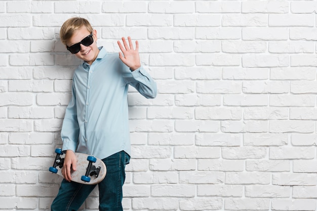 Vooraanzicht van moderne jongen met skateboard en exemplaarruimte