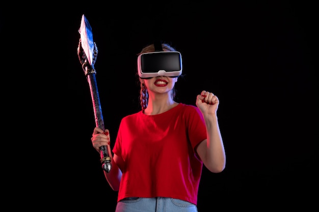 Vooraanzicht van mooie vrouw die vr speelt met strijdbijl dark