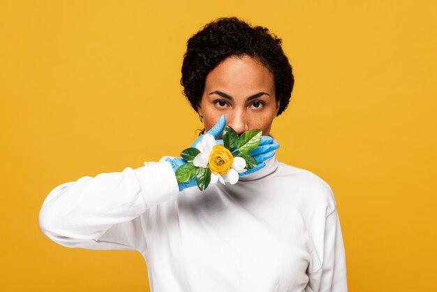 Vooraanzicht van mooie vrouw met bloemenhandschoenen die haar mond behandelen