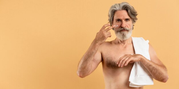 Vooraanzicht van oudere bebaarde man met handdoek room toe te passen