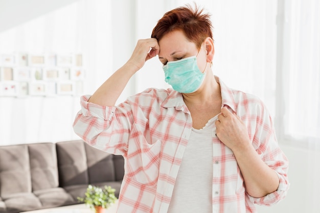 Vooraanzicht van oudere vrouw die op medisch masker zet