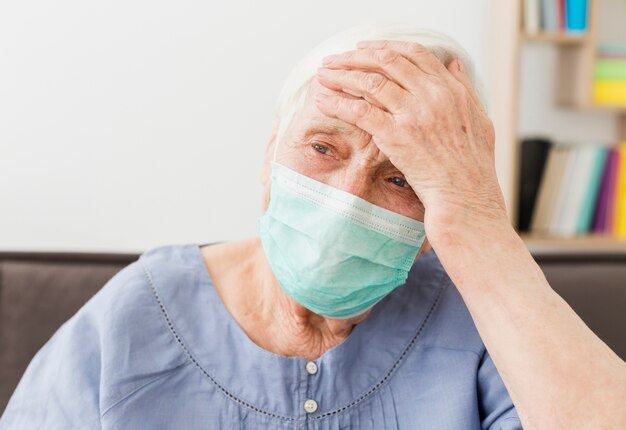 Vooraanzicht van oudere vrouw met medisch masker ziek voelen