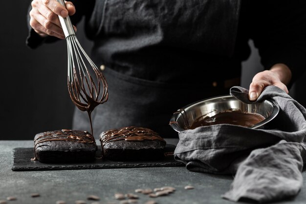 Vooraanzicht van patissier die cake met chocolade voorbereidt