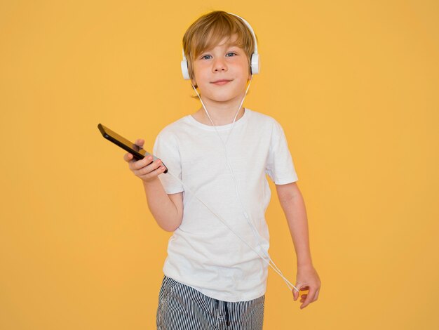 Vooraanzicht van schattige kleine jongen luisteren naar muziek