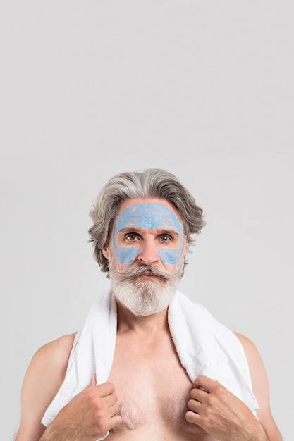 Vooraanzicht van senior man met gezichtsmasker en handdoek