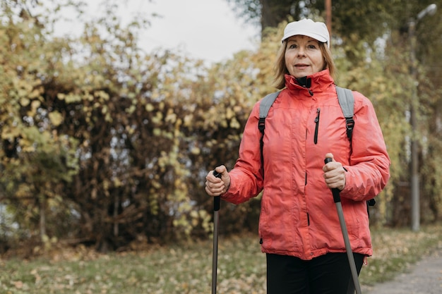 Gratis foto vooraanzicht van senior vrouw buiten wandelen met kopie ruimte