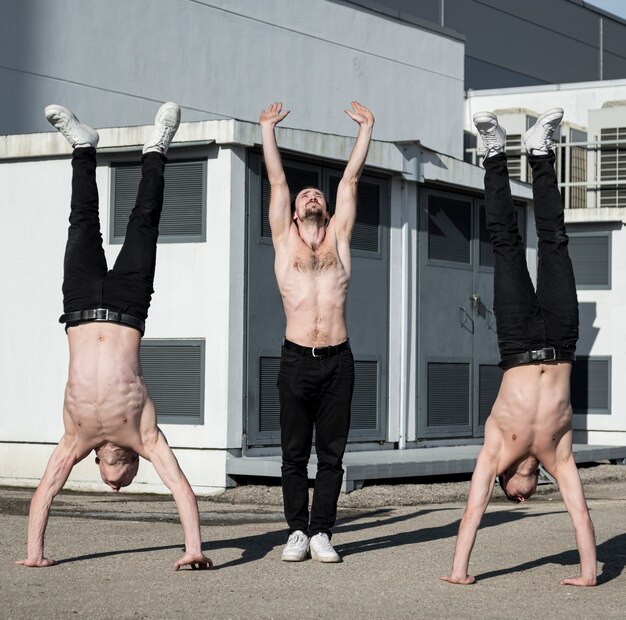 Gratis foto vooraanzicht van shirtless hiphopartiesten die routine buiten oefenen