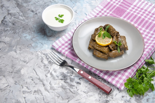 Vooraanzicht van smakelijke blad dolma binnen plaat op wit oppervlak