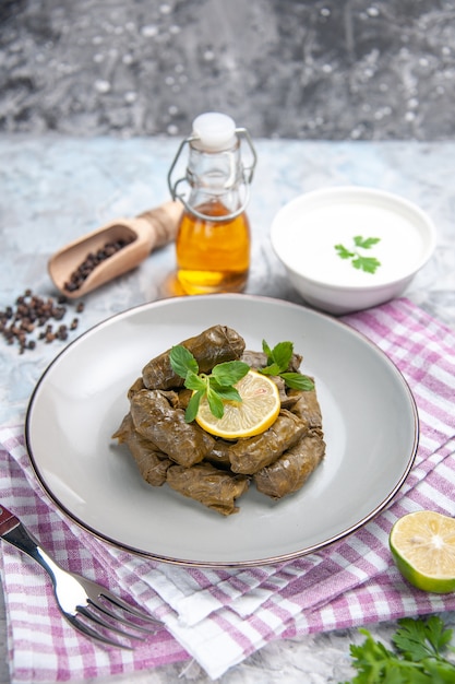 Vooraanzicht van smakelijke blad dolma met yoghurt op witte ondergrond