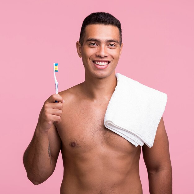 Vooraanzicht van smiley man met tandenborstel en handdoek