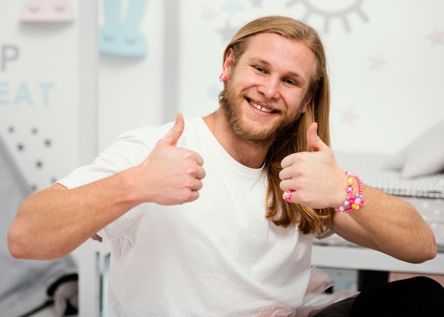 Vooraanzicht van smiley vader poseren thuis met duimen omhoog