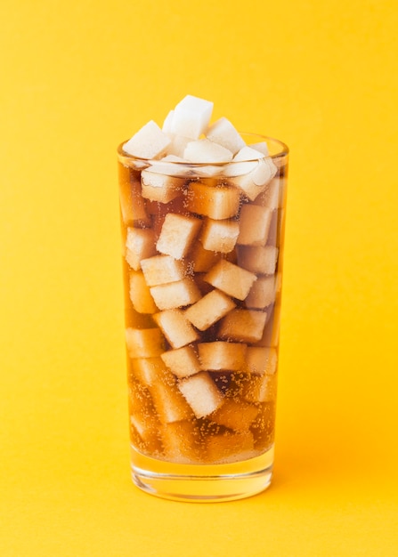 Vooraanzicht van suikerklontjes in glas met frisdrank