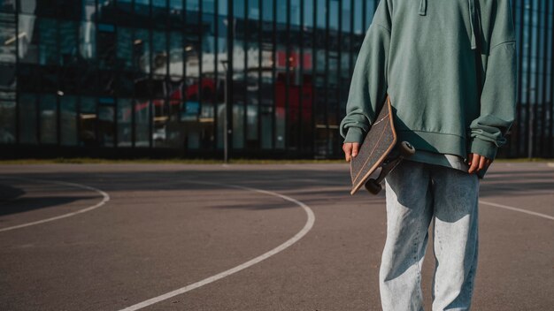 Vooraanzicht van tiener met skateboard buitenshuis en kopieer de ruimte