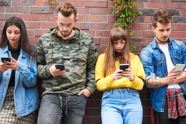 Vooraanzicht van twee jonge stellen met mobiele telefoon