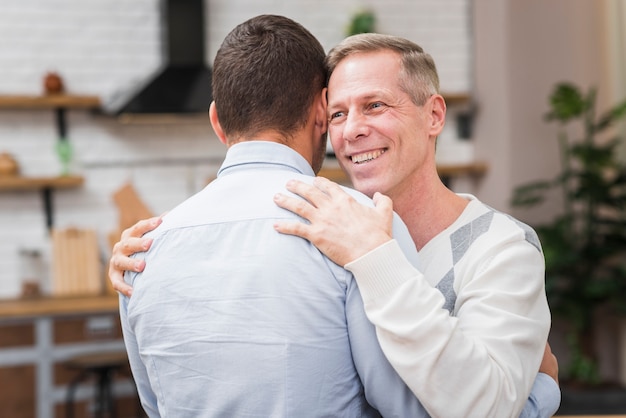 Gratis foto vooraanzicht van vader en zoon knuffelen