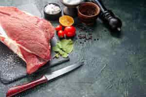 Gratis foto vooraanzicht van vers rauw rood vlees op zwarte lade peper zout citroen houten hamer mes op donkere kleur achtergrond