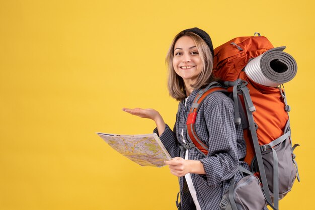 Vooraanzicht van vrolijke reizigersvrouw met de kaart van de rugzakholding