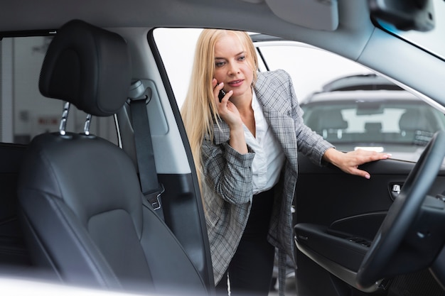 Vooraanzicht van vrouw die autobinnenland controleert