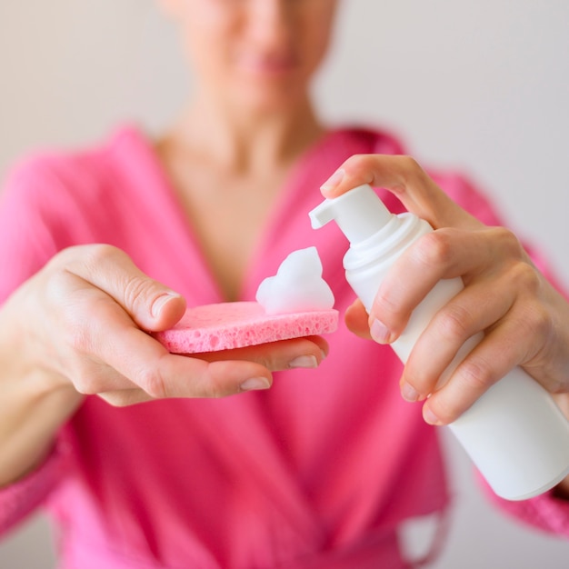 Vooraanzicht van vrouw die gezichtsreinigingsmiddel gebruiken