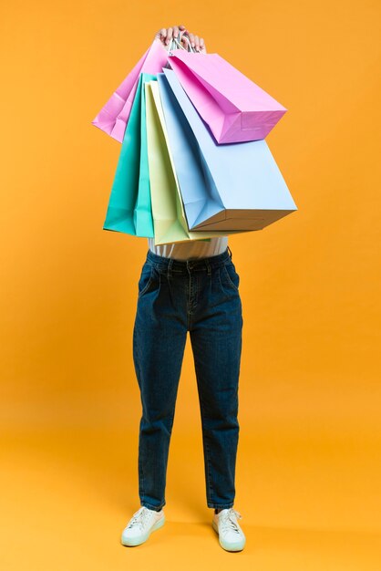 Vooraanzicht van vrouw die verkoop het winkelen zakken steunt