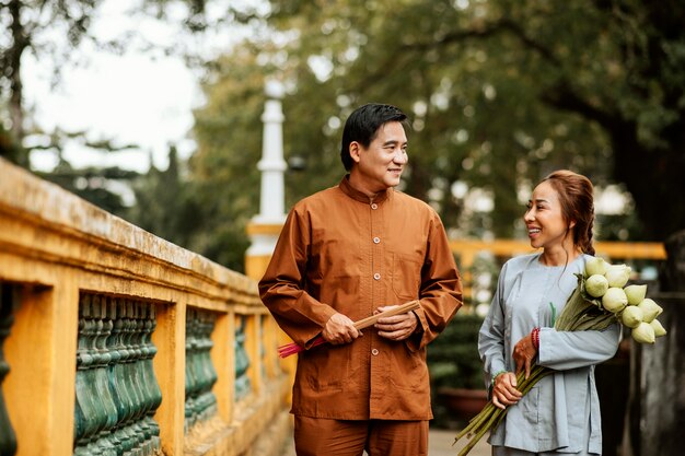 Vooraanzicht van vrouw en man met boeket bloemen in de tempel en wierook