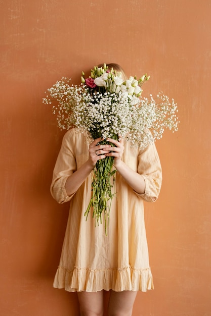 Gratis foto vooraanzicht van vrouw met boeket van prachtige lentebloemen